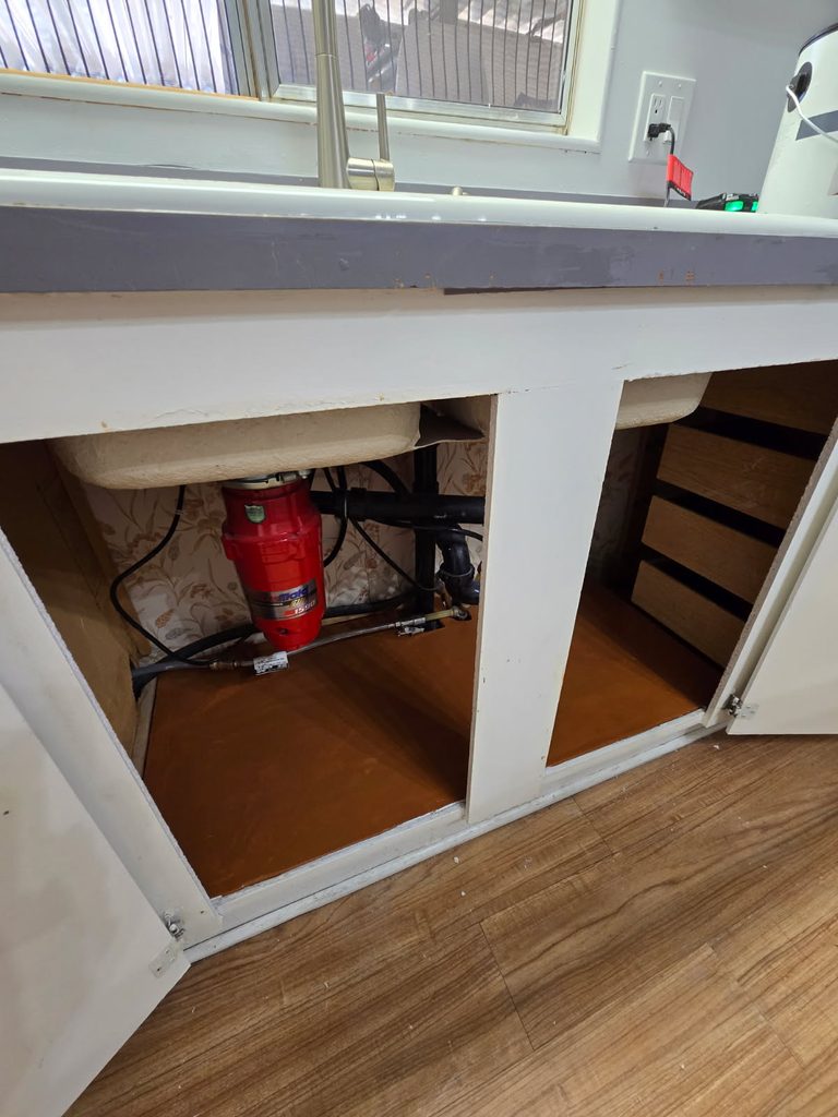 Repaired and reinforced kitchen sink cabinet base completed by Blue Line Home Services. 